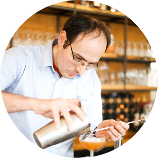 Fefe Kovacs preparing a cocktail at a bar