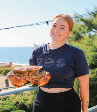 hive beach cafe staff member holding a crab