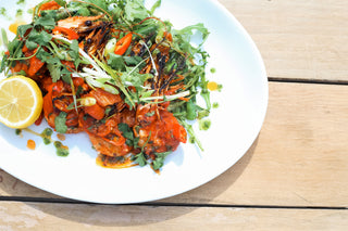 plated dish of giant prawns with salad and herbs